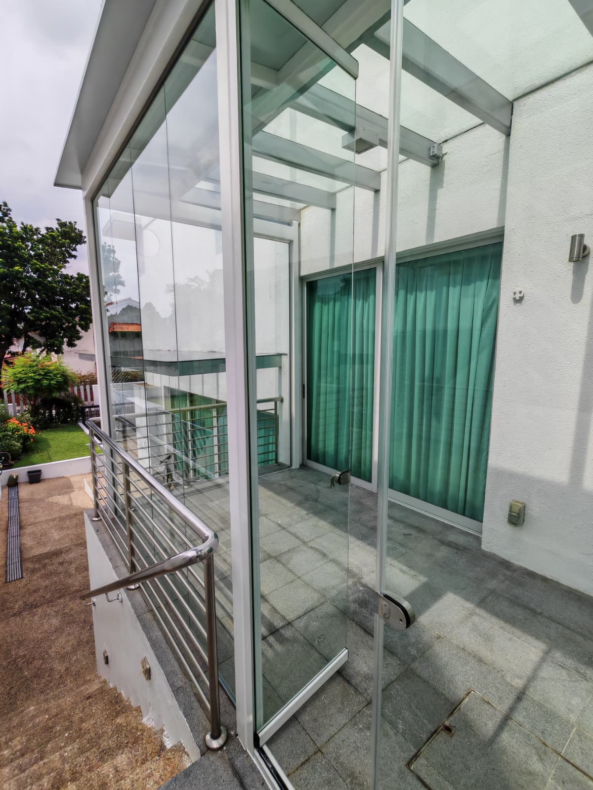Completed GLASSVIEW Malaysia project with clear glass panels enclosing a residential outdoor space.